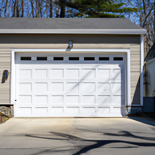 Suburban Hanover driveway with a modern sectional garage door on a New England home, no people.
